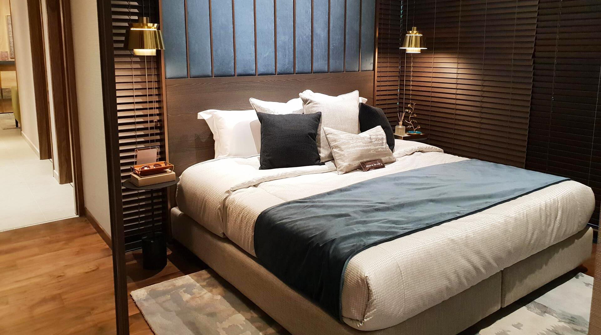 Un lit et sa tête de lit dans un intérieur de chambre au style boisé