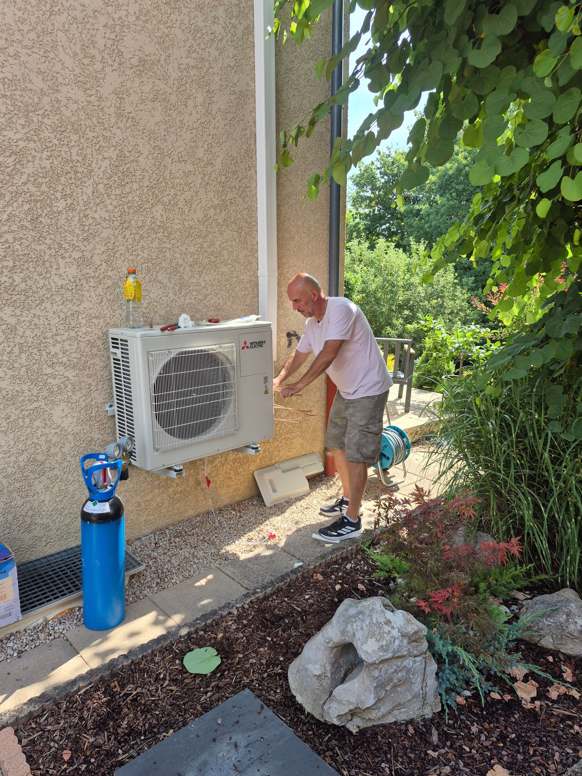 Un technicien entretien une climatisation.