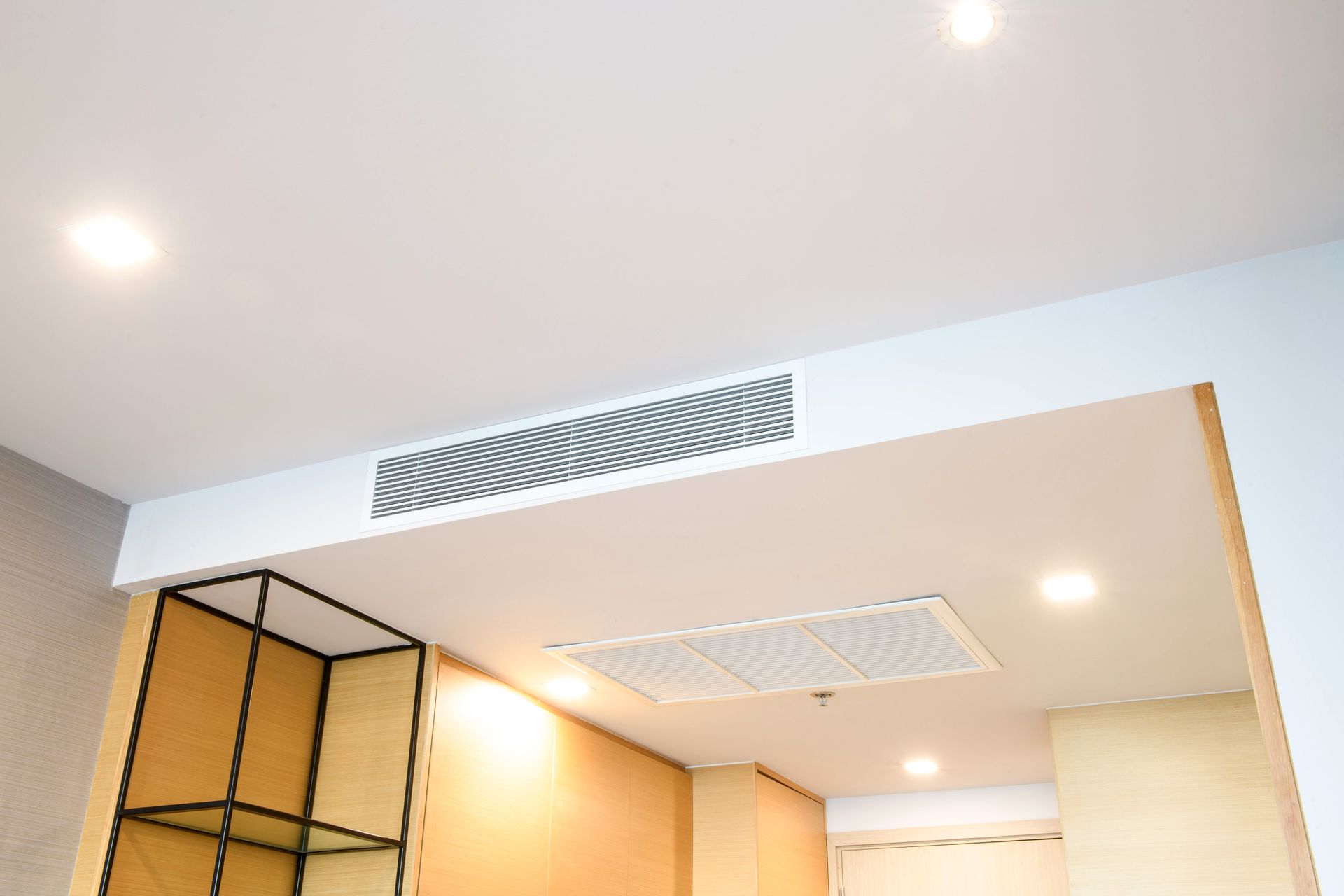 Couloir de bureau moderne avec plafond blanc, éclairage encastré et murs lambrissés