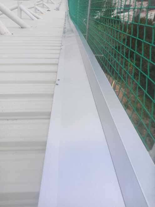 Un techo blanco con una valla verde que lo rodea.