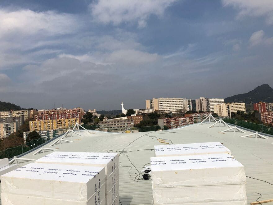 Un techo con muchas cajas encima y una ciudad al fondo.