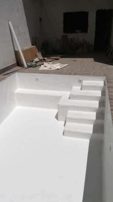 Una piscina blanca con escaleras que conducen a ella.