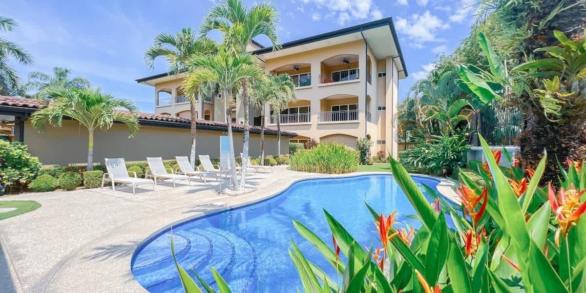 A large house with a large swimming pool in front of it.