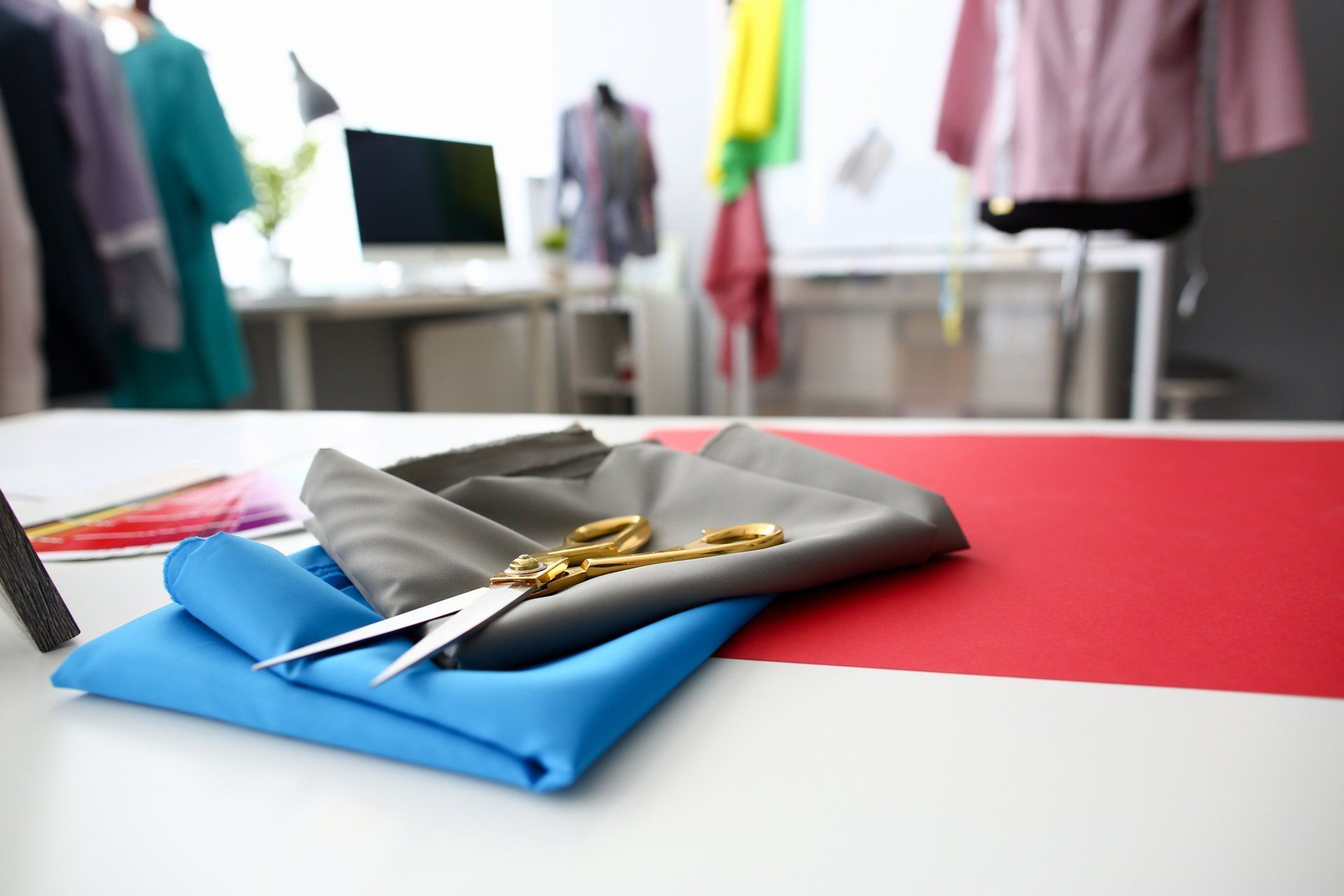 Des tissus et une paire de ciseaux disposés sur une table dans un atelier de couture.
