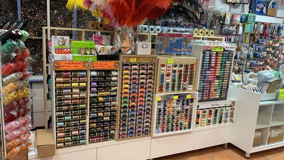 Étagères de bobines de fil de couture multicolores dans un rayon mercerie.