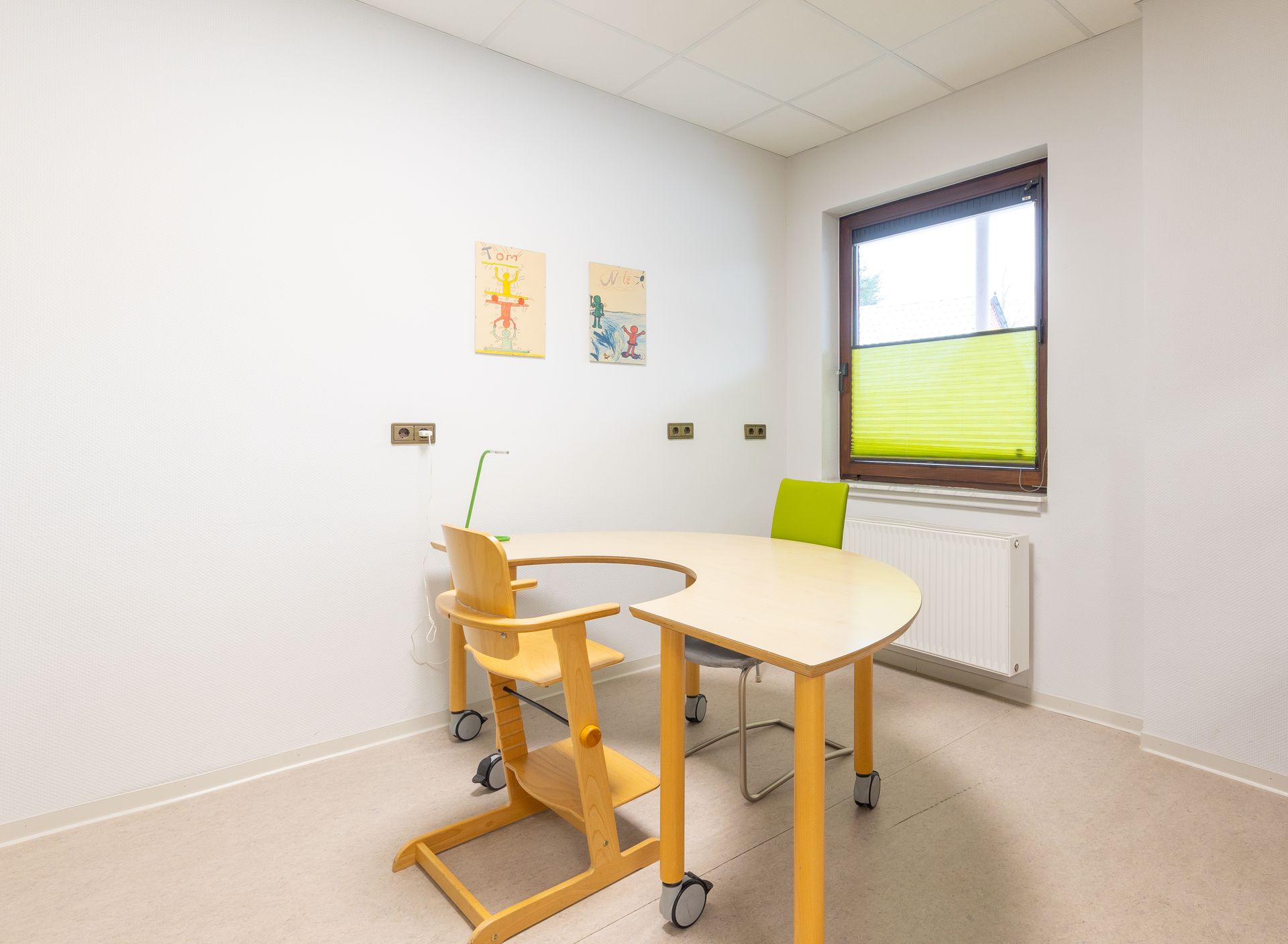 Ein kleiner Raum mit einem Tisch, Stühlen und einem Fenster.