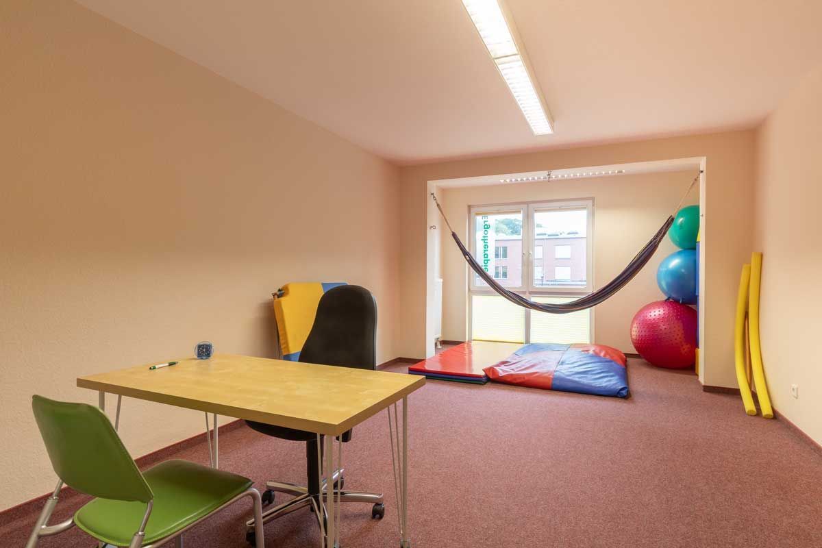 Ein Raum mit einem Tisch und Stühlen und einer Hängematte, die von der Decke hängt.