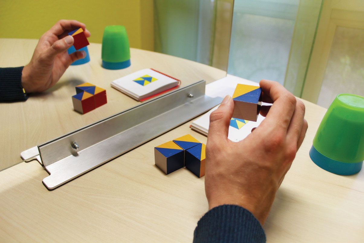 Eine Person spielt ein Spiel mit einem Lineal und Bechern