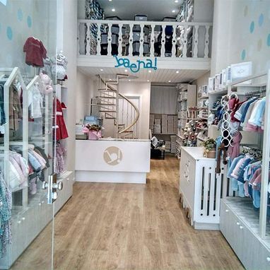 Una tienda llena de ropa y una escalera de caracol.