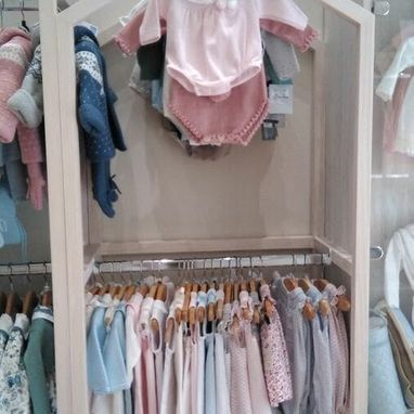 Un armario lleno de ropa de bebé colgada en percheros.