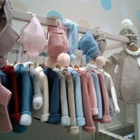 Una fila de ropa de bebé colgada en un perchero en una tienda.