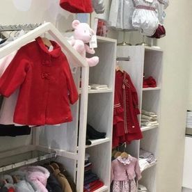 Un armario lleno de ropa y un osito de peluche.