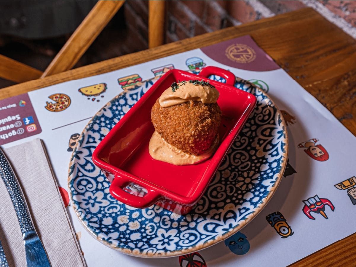 Un plato de comida con un cuenco rojo encima, sobre una mesa.