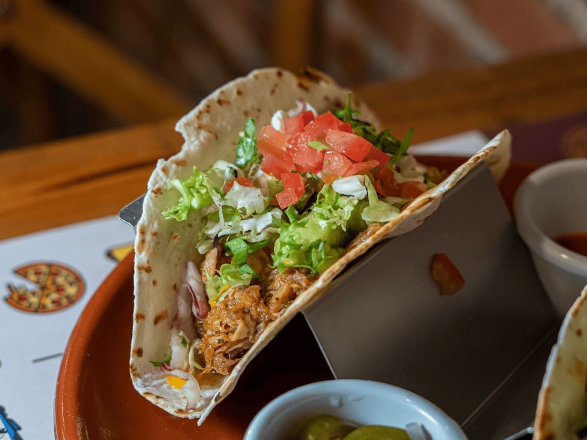 Un primer plano de un taco en un plato sobre una mesa.