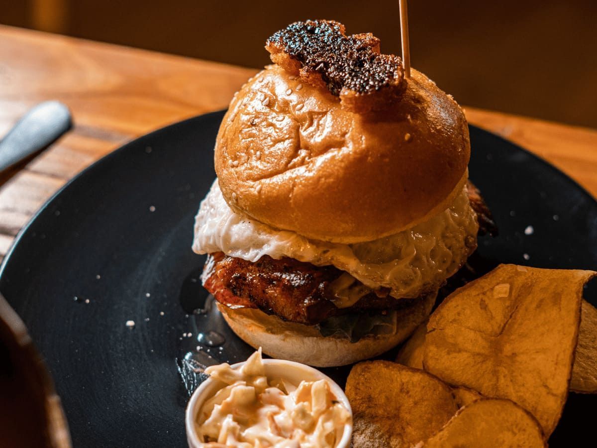 Un primer plano de una hamburguesa en un plato sobre una mesa.