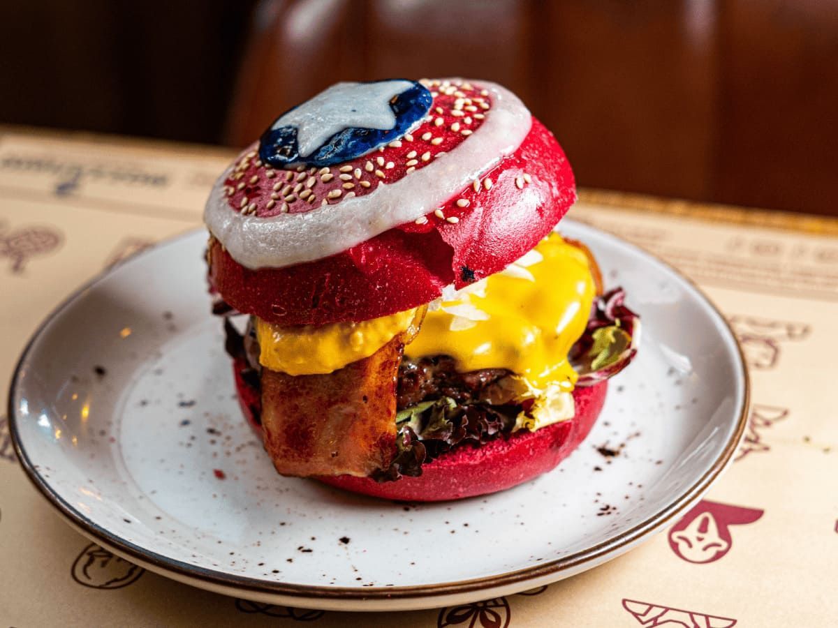 Una hamburguesa con un escudo del Capitán América está en un plato.