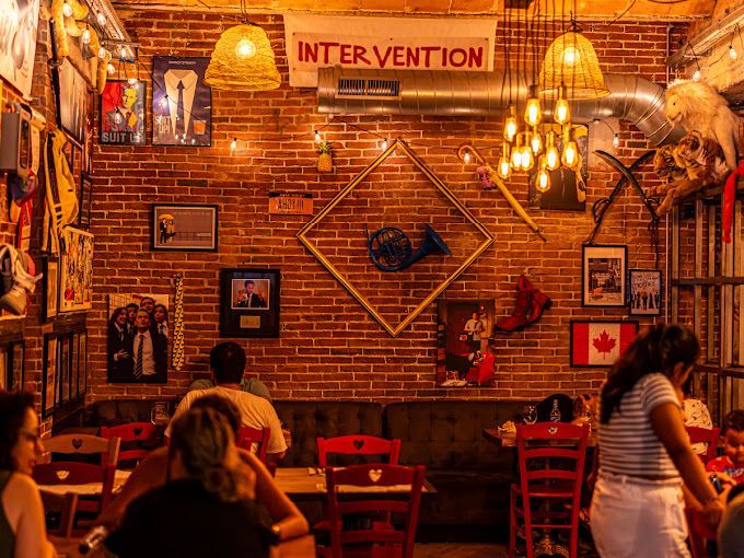 Un grupo de personas están sentadas en mesas en un restaurante.
