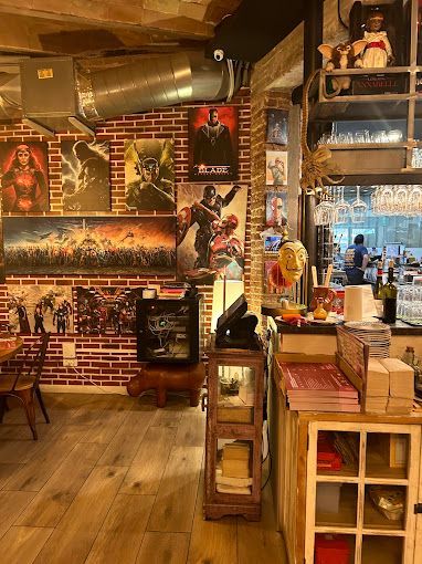 Un restaurante con muchos carteles en la pared y mesas y sillas.