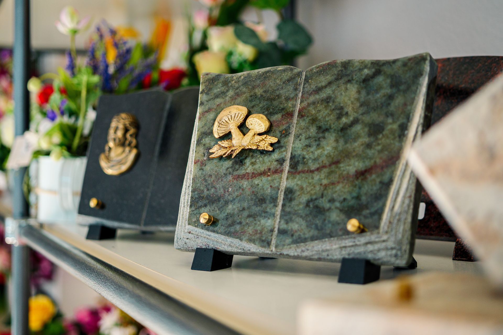 Plaque funéraire en marbre en forme de livre ouvert sur un présentoire
