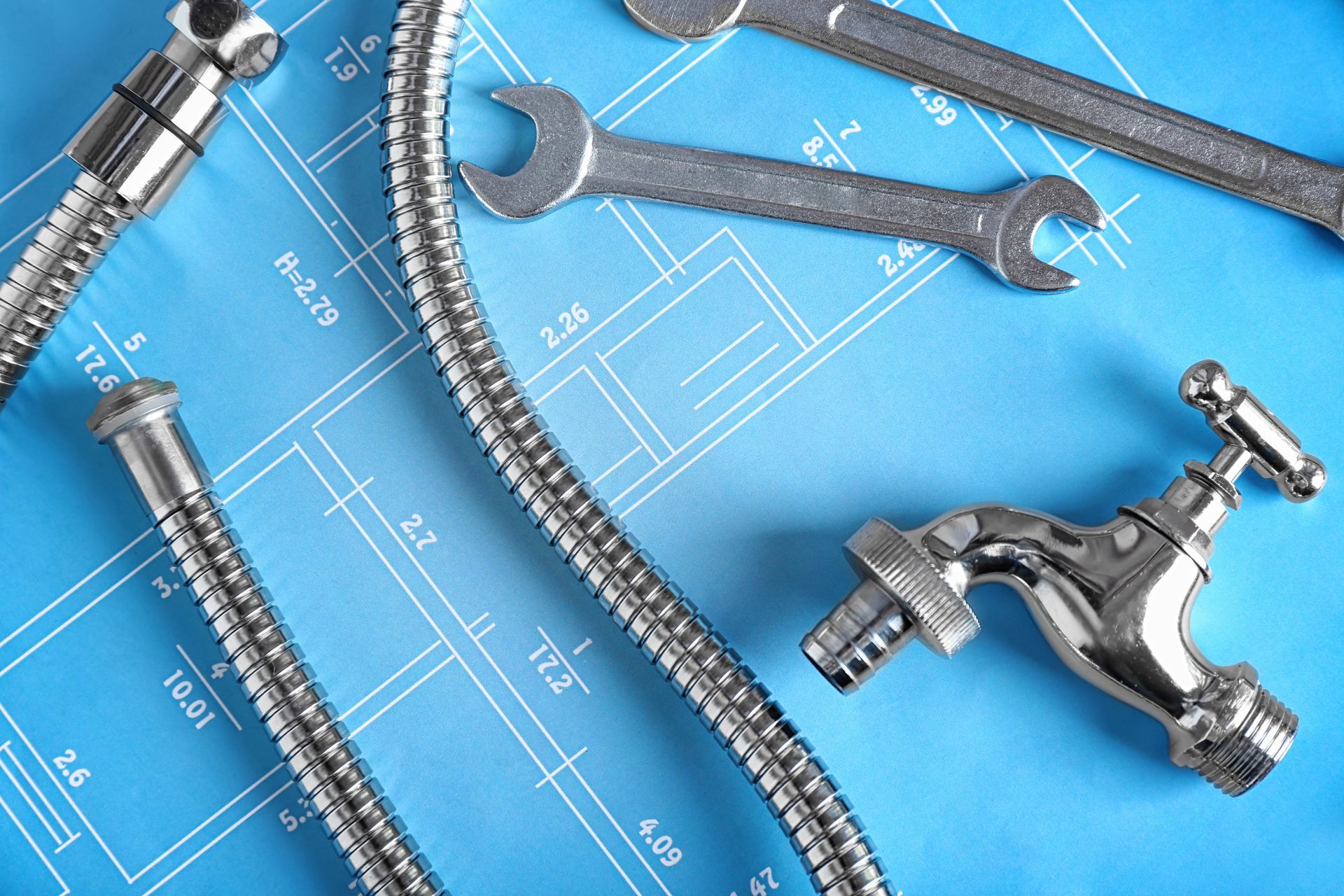 Un flexible avec un robinet et deux clés à fourche sur un schéma de salle de bains.