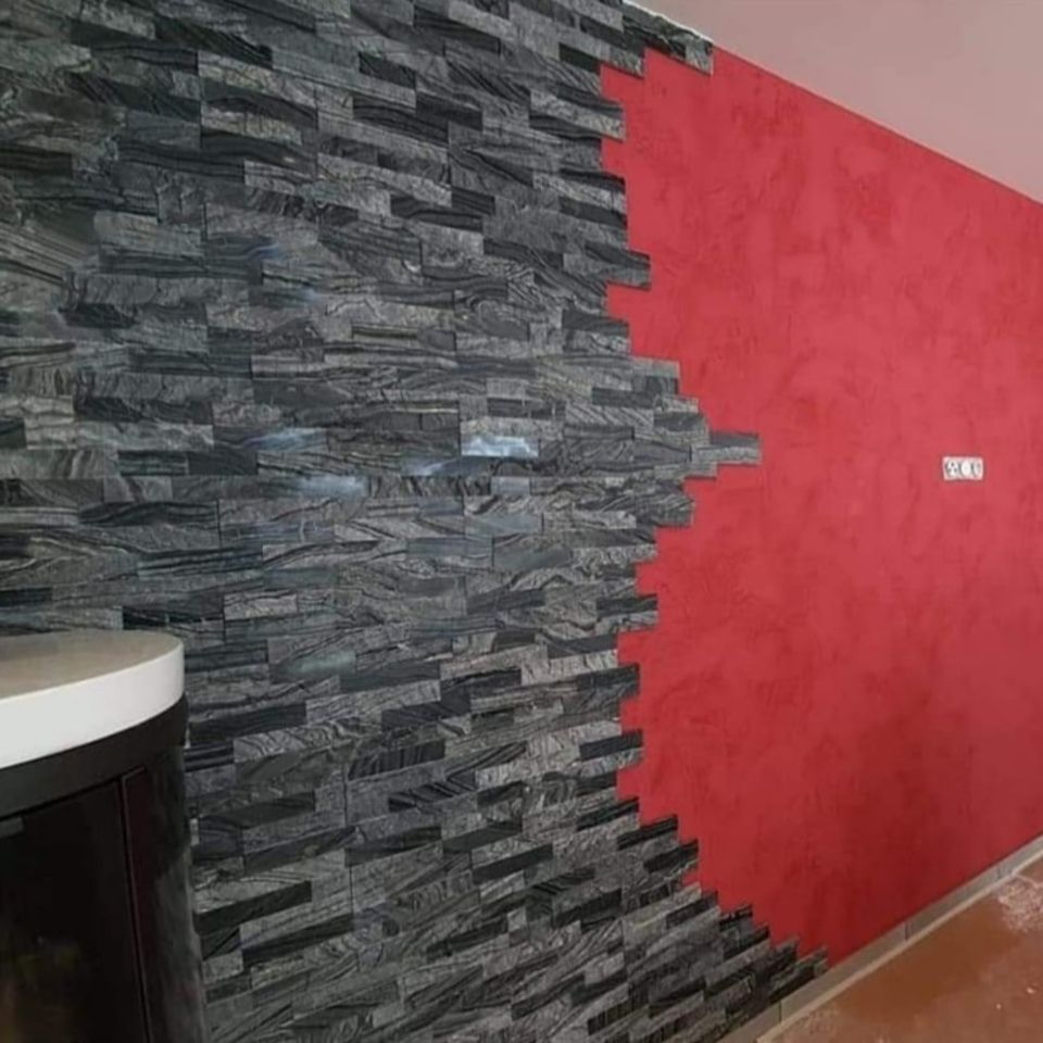 Une pièce avec un mur en pierre et un mur rouge.