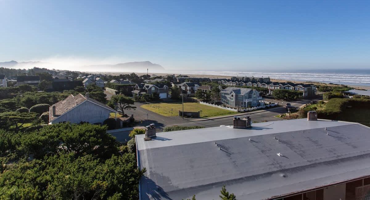 Aerial or exterior view of Gearhart by the Sea property with ocean and dunes