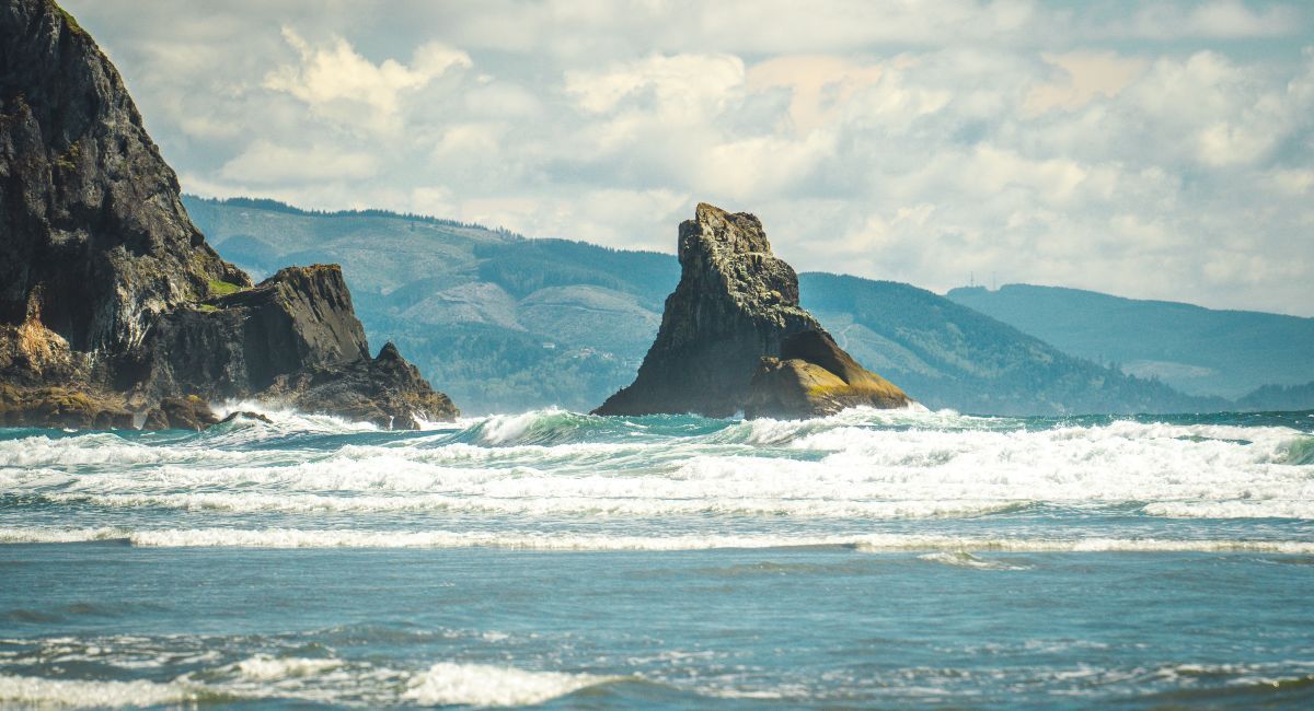 Crashing waves of white water against a rugged, rocky Oregon coastline create a beautiful nature sce