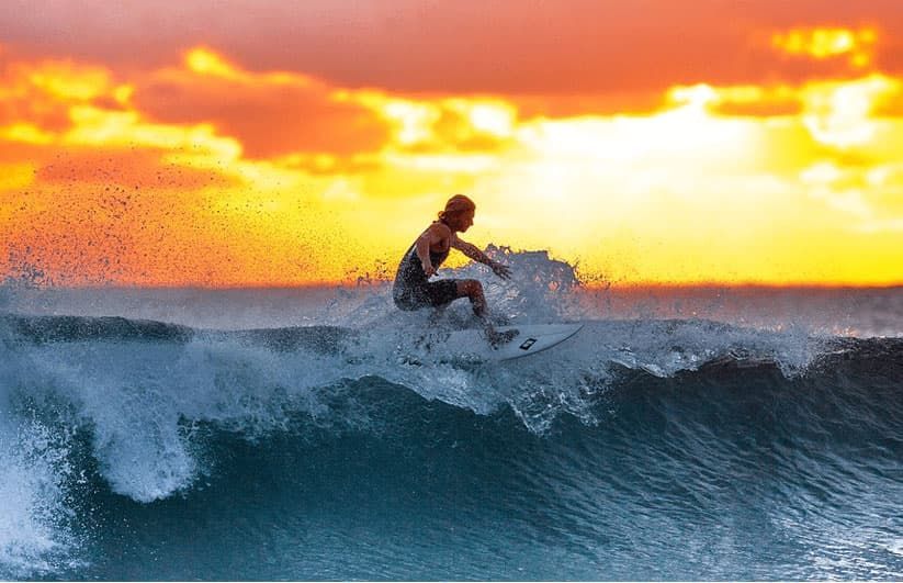surfer in in wetsuits surfing in the pacific ocean along the Oregon coast