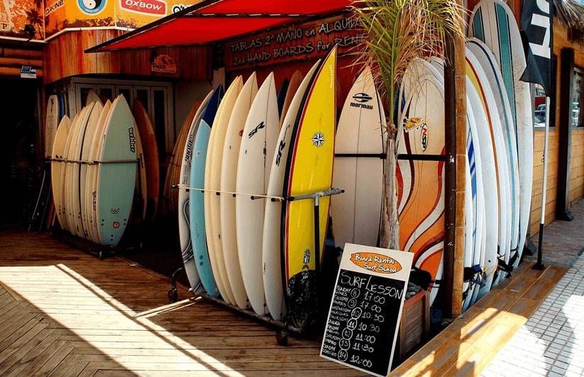 Multiple colorful surfboards lined up at a surf rental shop in Ecola State Park