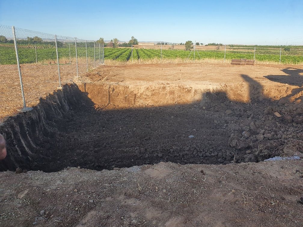 Una persona está cavando un hoyo en la tierra de un campo.