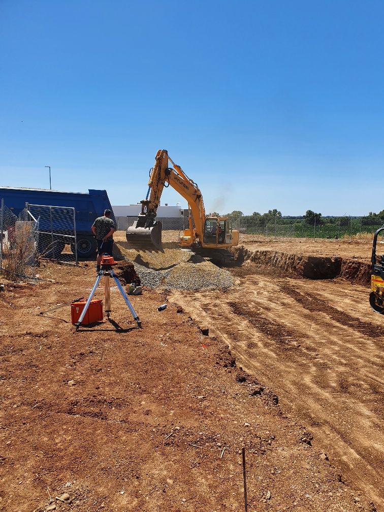 Una obra en construcción con mucha tierra y mucha maquinaria.