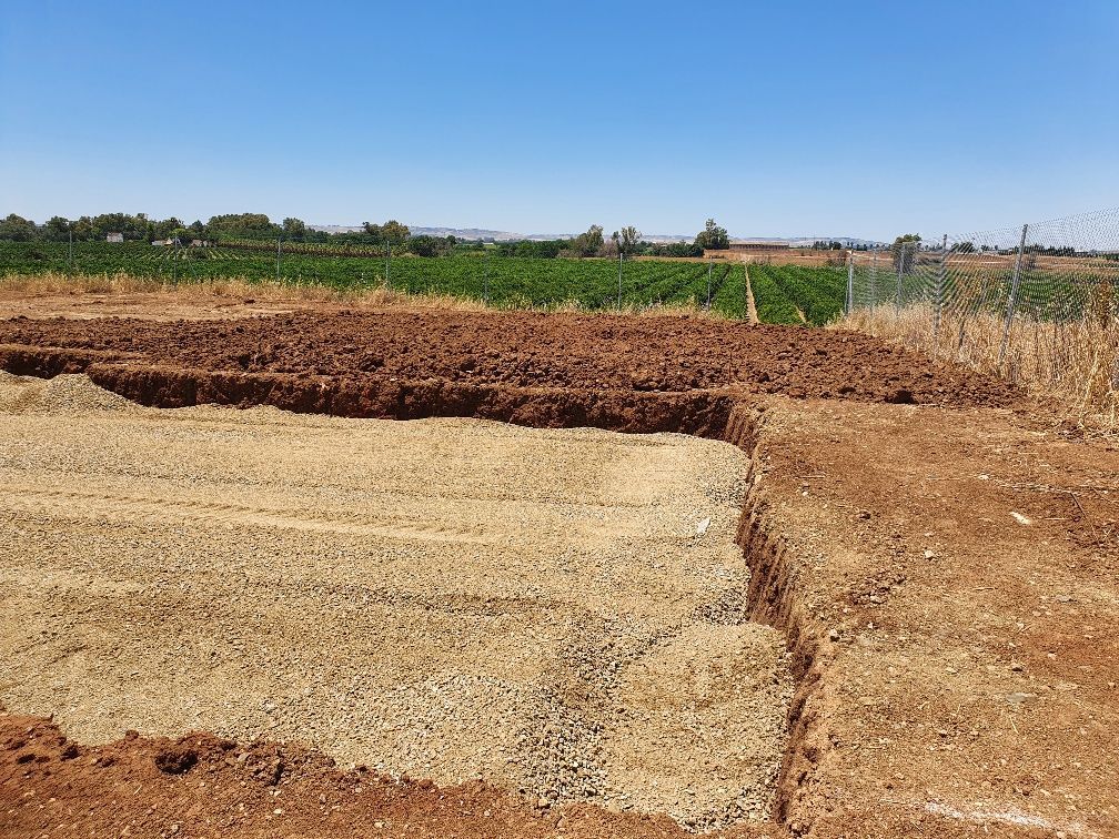 Un campo de tierra con un cielo azul al fondo