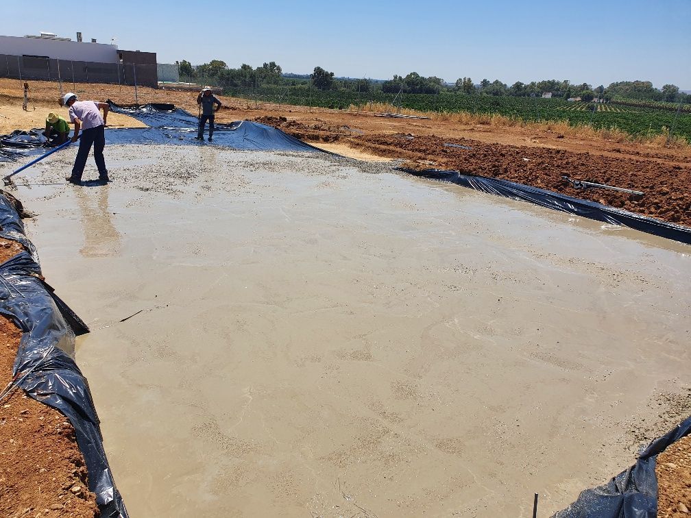 Dos hombres están trabajando en una superficie de hormigón en un campo.