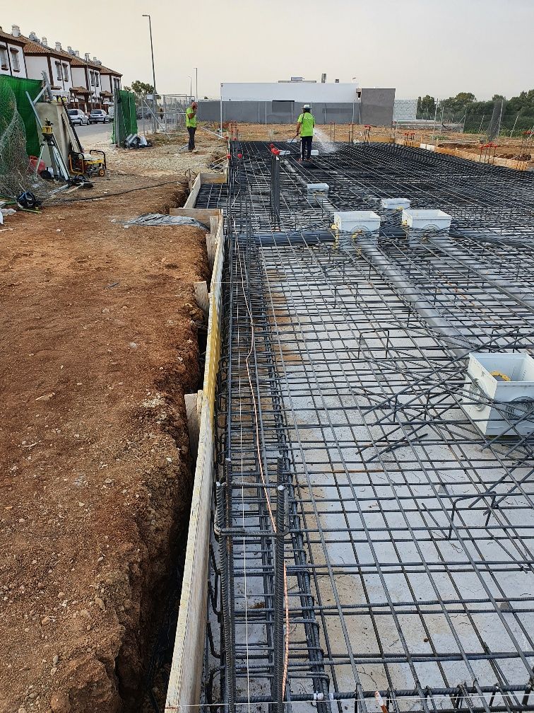 Un sitio de construcción con muchas barras de acero en el suelo.