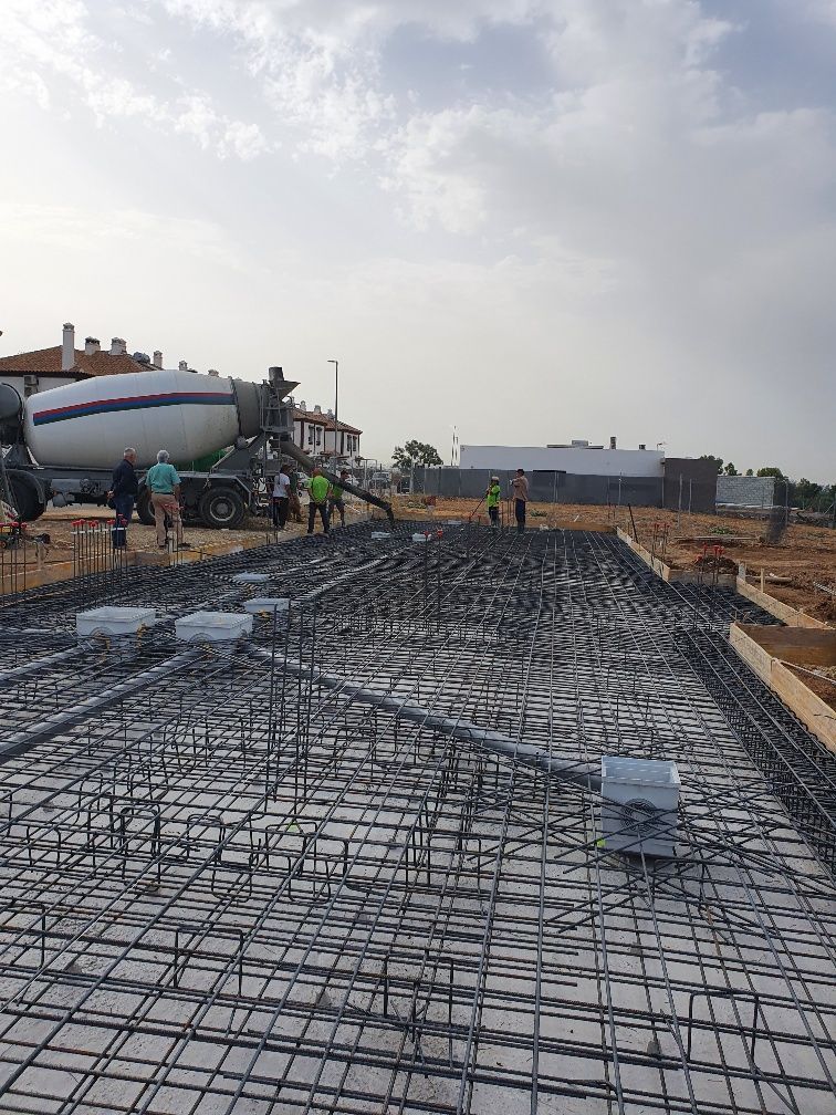 Una hormigonera está vertiendo hormigón en una losa de hormigón en un sitio de construcción.