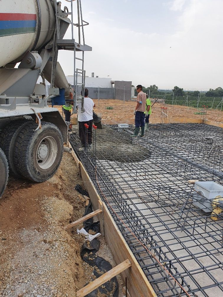 Un camión de hormigón está vertiendo hormigón en una obra en construcción.