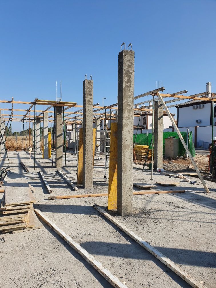 Una obra en construcción con muchos pilares de hormigón y andamios.