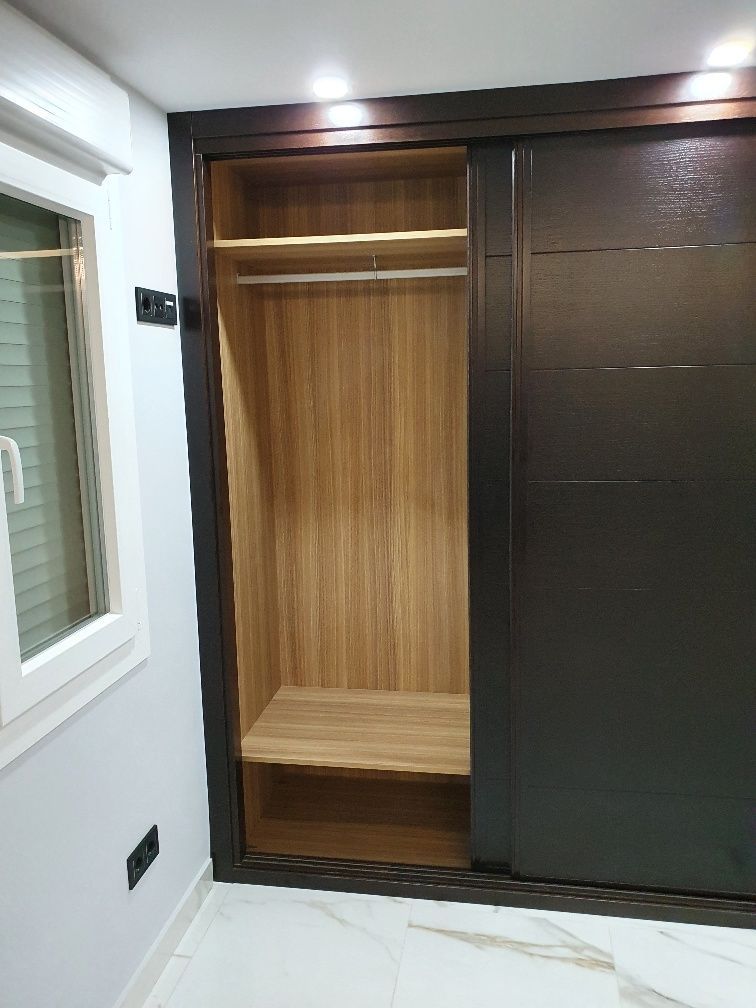 Un armario con puertas correderas y una ventana en una habitación.