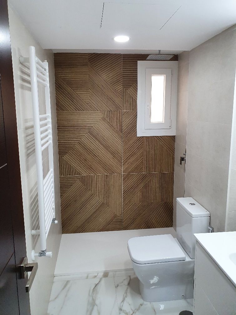 Un baño con inodoro y ventana.