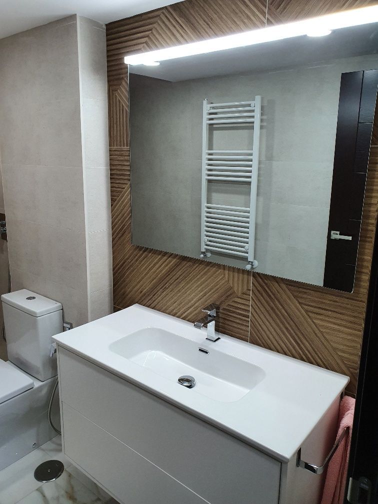 Un baño con lavabo, inodoro y espejo.