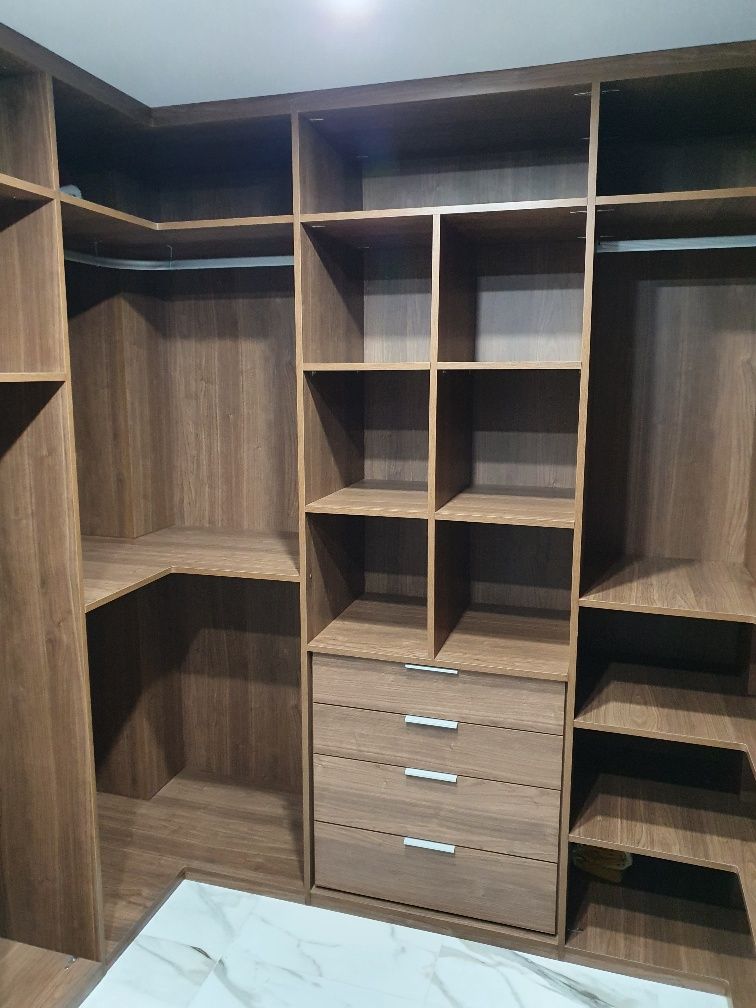 Un vestidor con muchos estantes y cajones.