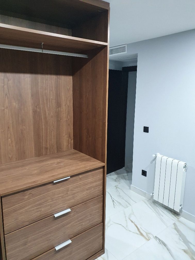 Una habitación con una cómoda y un radiador dentro.