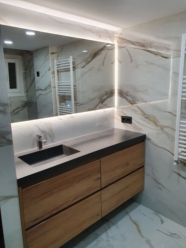 Un baño con lavabo, espejo y toallero.