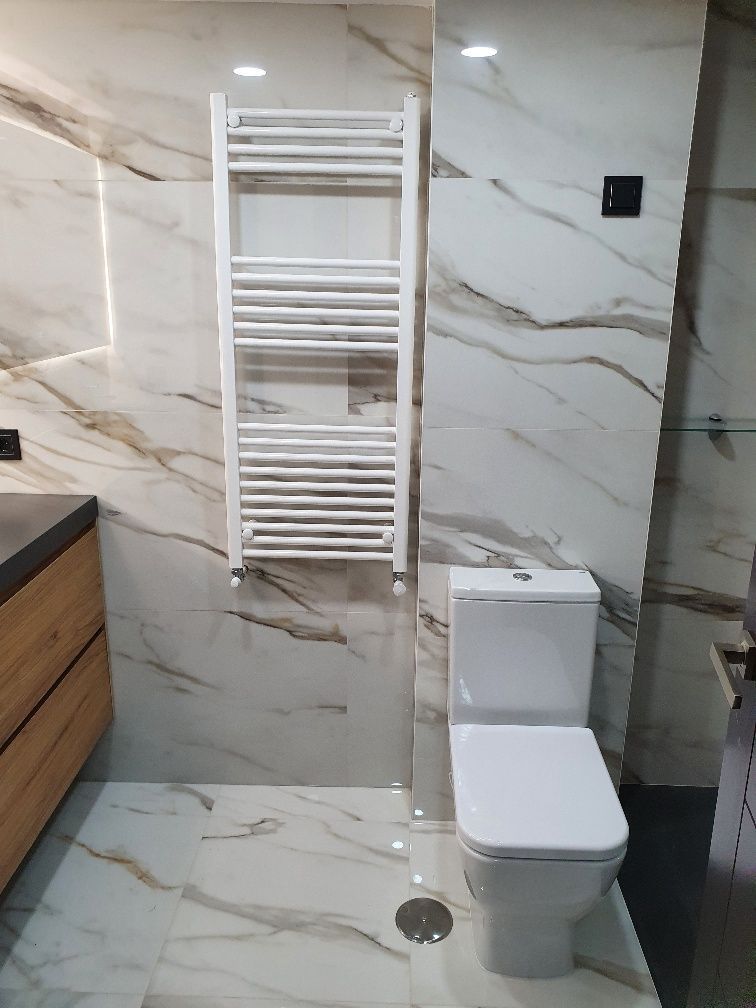 Un baño con inodoro y toallero.