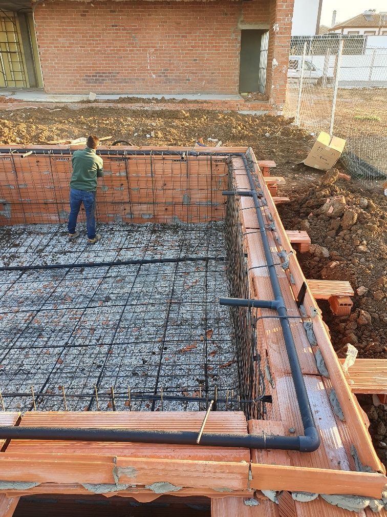 Un hombre está parado en medio de una piscina en construcción.