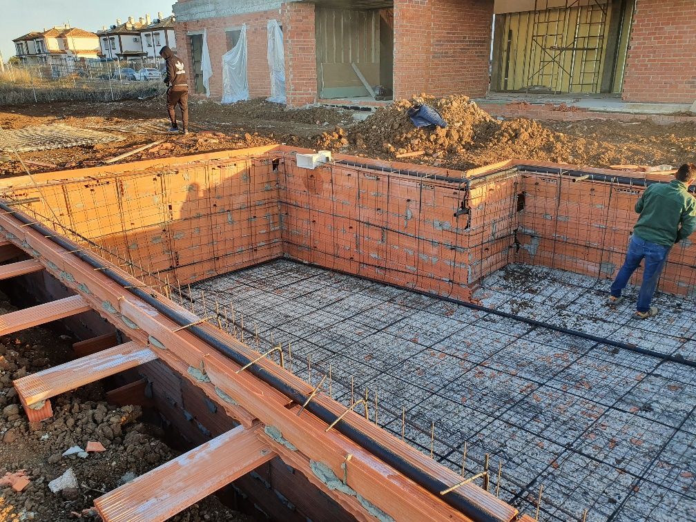 Un hombre está trabajando en los cimientos de una piscina.