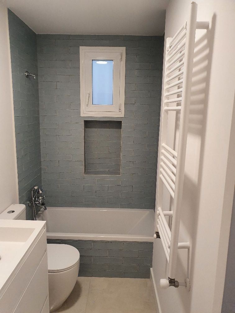 Un baño con inodoro, lavabo, bañera y ventana.