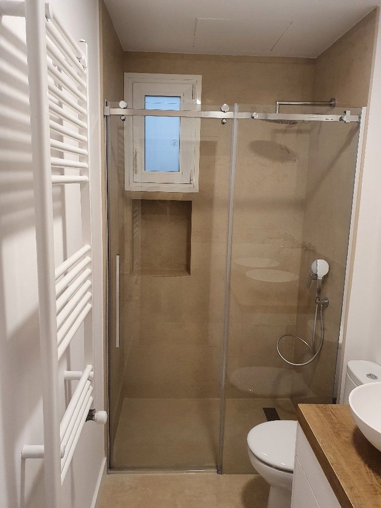 Un baño con puerta de ducha corrediza de cristal y un inodoro.