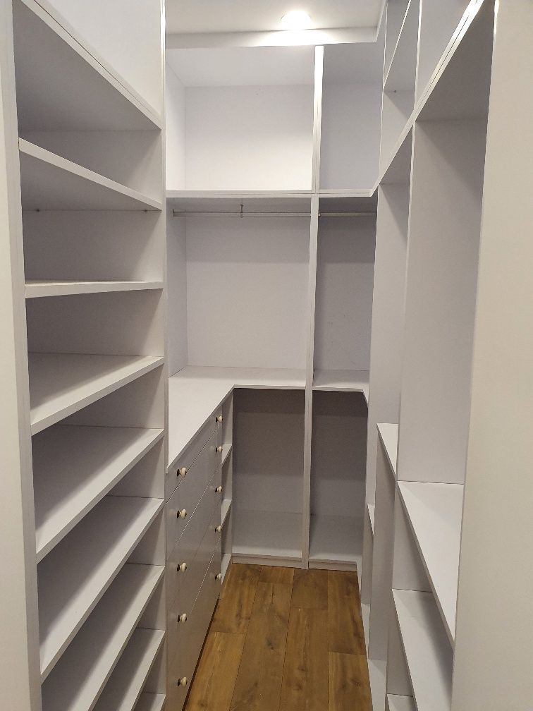 Un vestidor con muchos estantes y cajones.