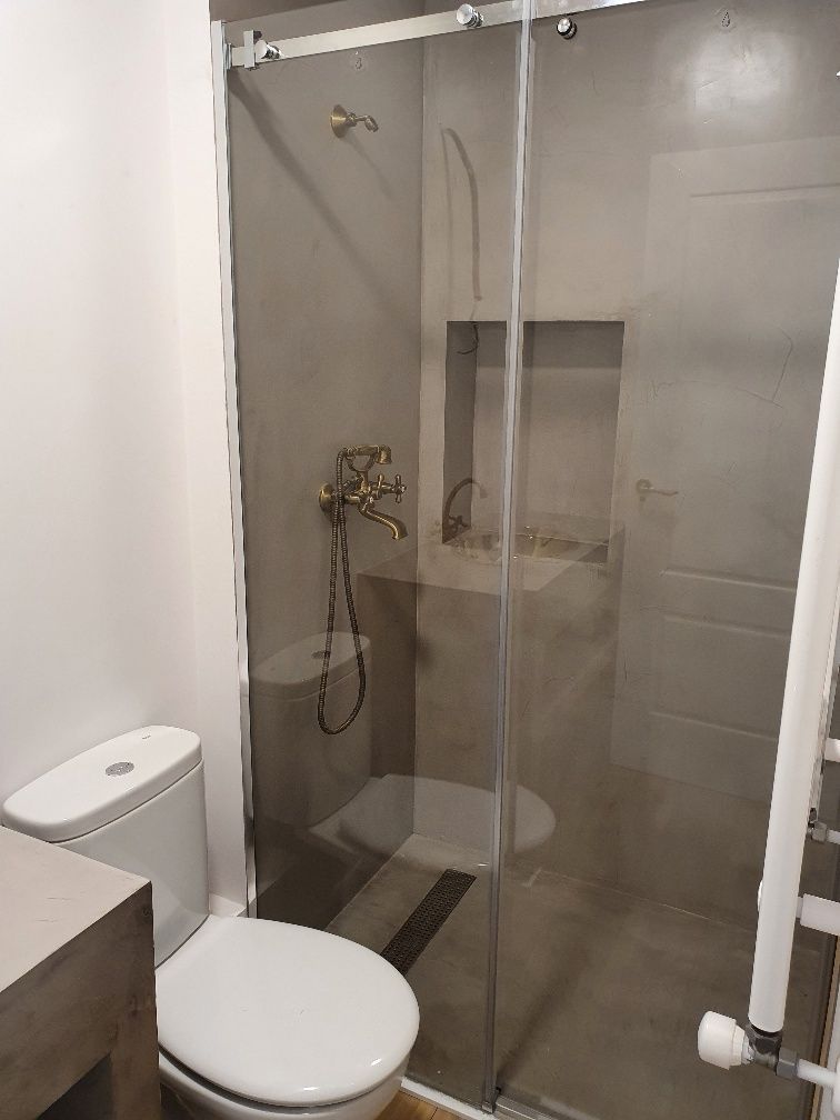 Un baño con inodoro, lavabo y ducha.